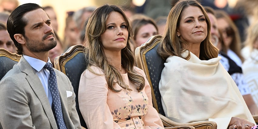 Vi ser prins Carl Philip, prinsessan Sofia och prinsessan Madeleine. De sitter ner under en konsert i Borgholm.