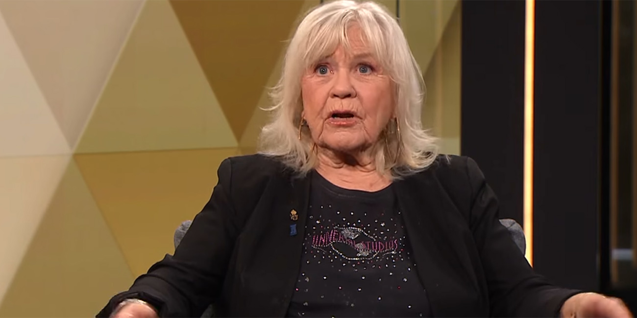 Vi ser Christina Schollin i en tv-studio, hon är klädd i svart och ser förvånad ut.