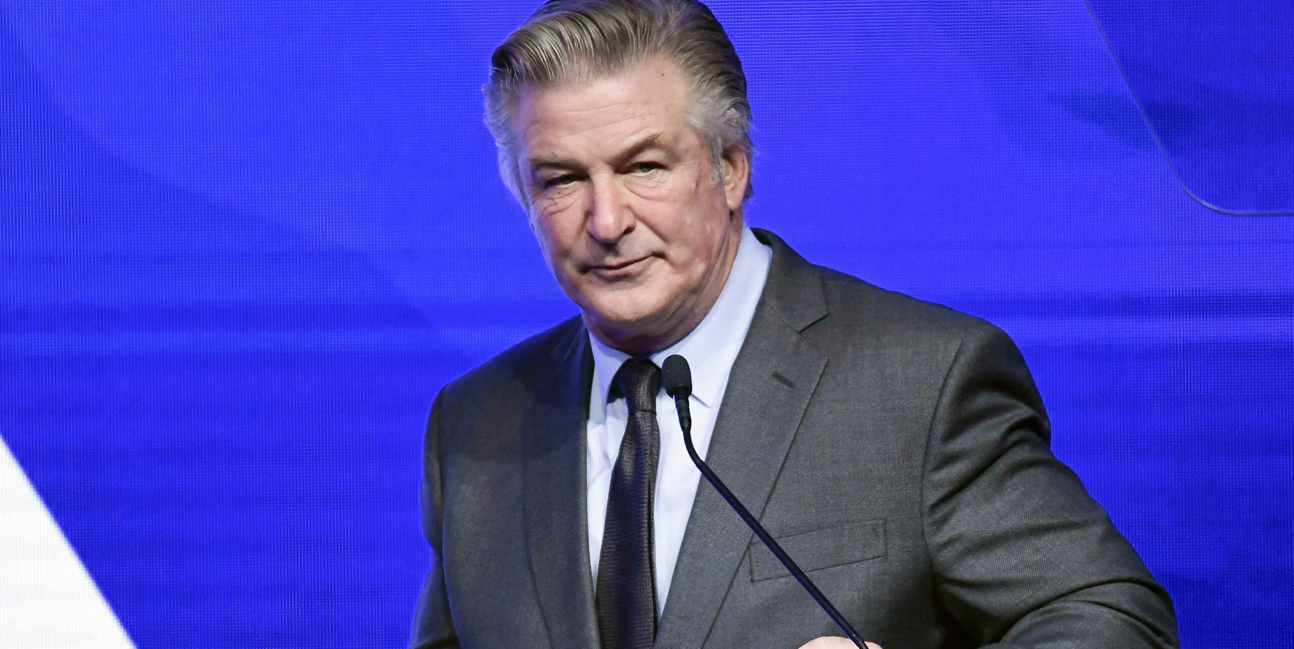 Vi ser Alec Baldwin vid ett podium.