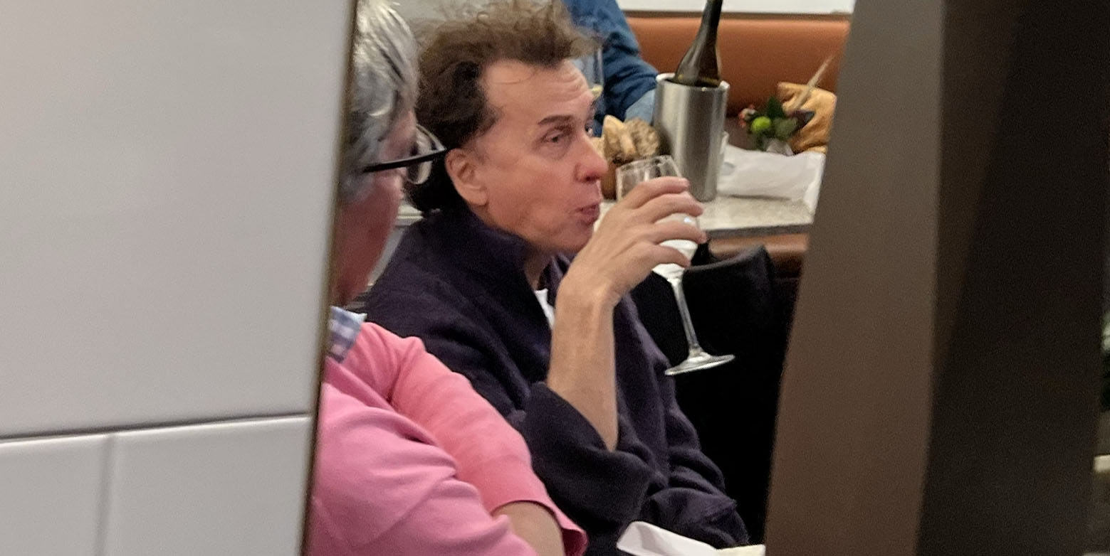 Vi ser en utmärglad Magnus Uggla dricka något ur ett glas.